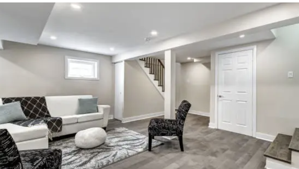 Open basement design with modern flooring, light walls, recessed lights, and flexible lounge seating arrangement.